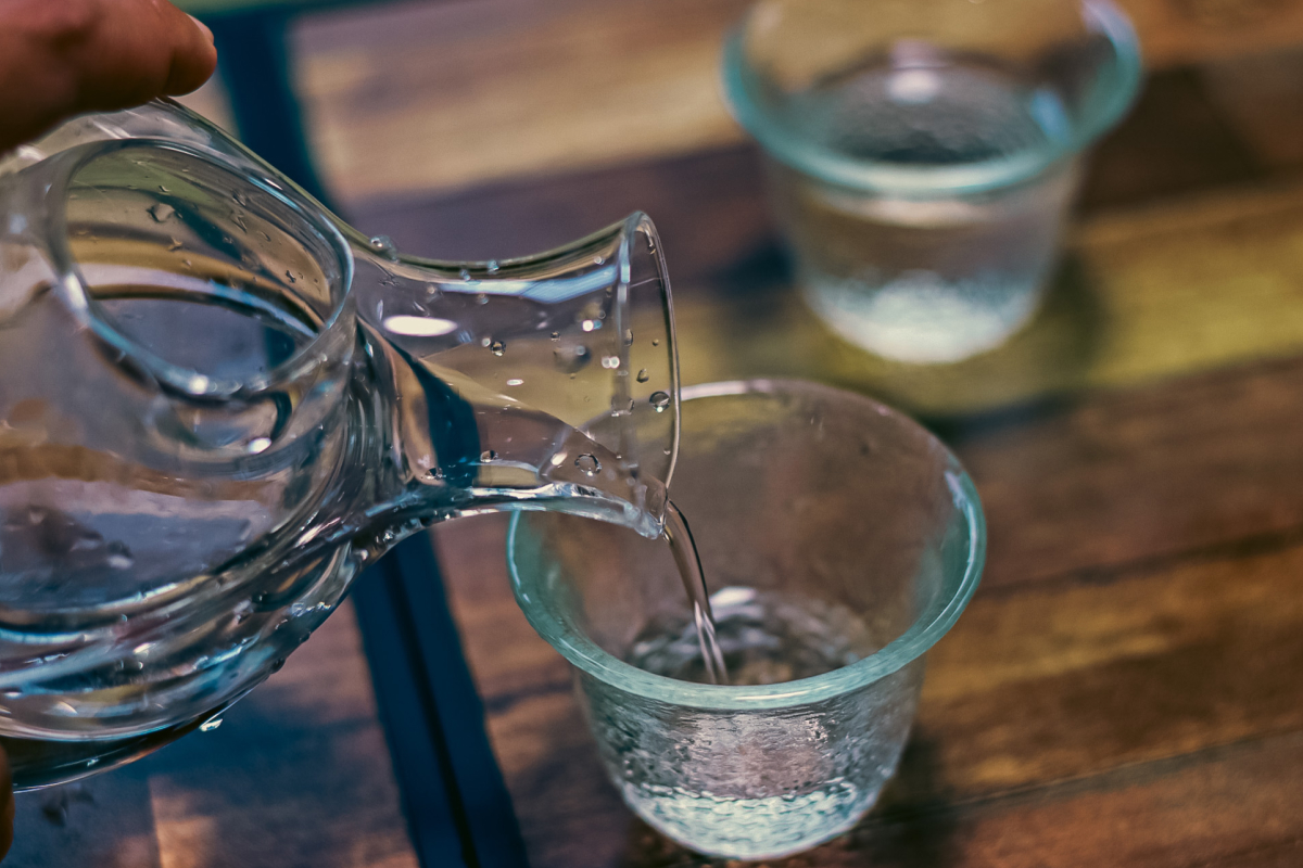透明なお猪口へ日本酒を注いでいる様子。